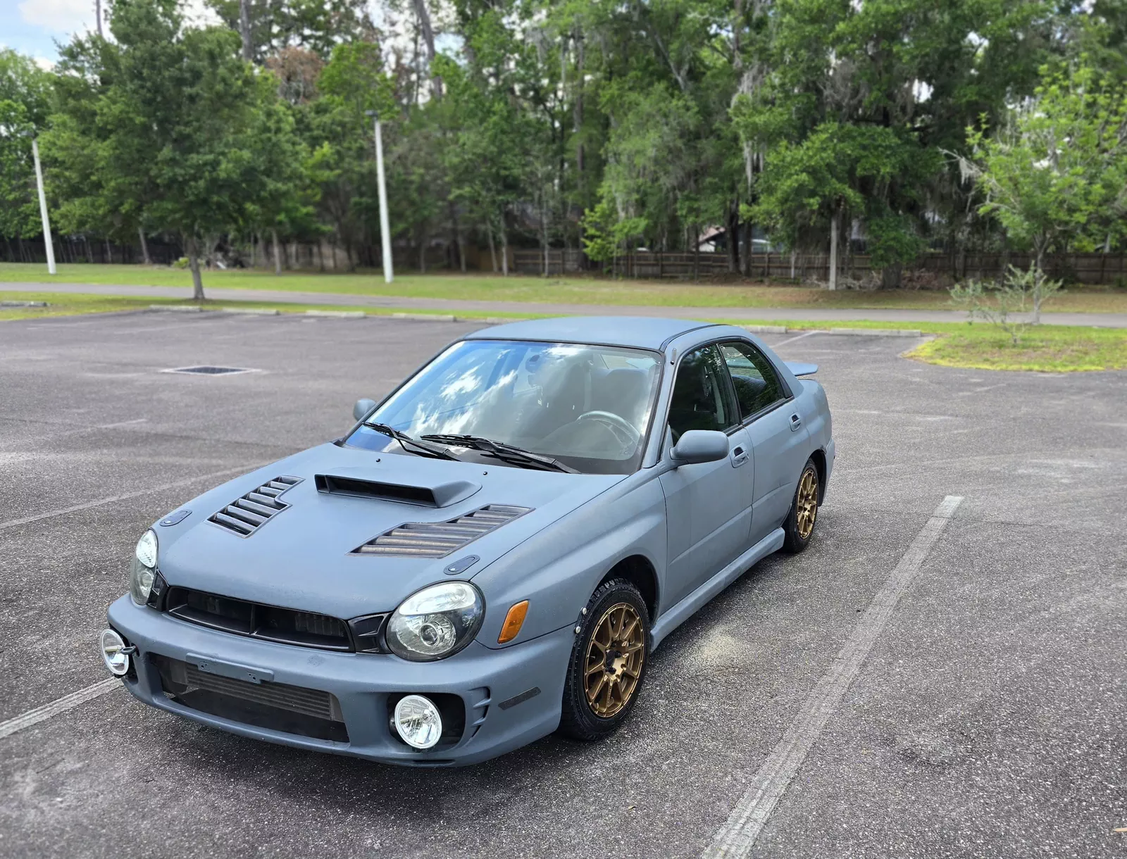 Front quarter view showing JDM STI bumper and carbon hood